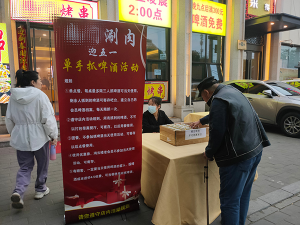 临近小长假，北京市朝阳区一家餐馆推出“迎五一”促销活动。人民网记者乔业琼摄